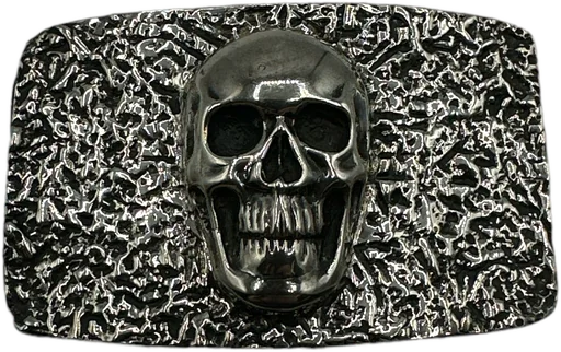 A sterling silver buckle with a raised skull at its center on a heavily textured ground.